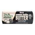 Wrapped roll of The Yorkshire Kitchen Black Summer Truffle Butter in black and cream packaging, featuring illustrations of truffles. Large white text reads ‘Black Summer Truffle Butter’ with the description ‘Luxuriously creamy with chunks of real truffle.’ The wrapper suggests ‘Stir into risotto’ and ‘Add to mashed potato,’ and includes ‘Crafted with love’ and ‘Small batch’ text.