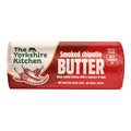 Wrapped roll of The Yorkshire Kitchen Smoked Chipotle Butter in red and cream packaging, featuring illustrations of chipotle chillies. Large white text reads ‘Smoked Chipotle Butter’ with the description ‘Deep smoky flavour with a squeeze of lime.’ The wrapper suggests ‘Melt on prawns’ and ‘Add to scrambled egg,’ and includes ‘Crafted with love’ and ‘Small batch’ text.